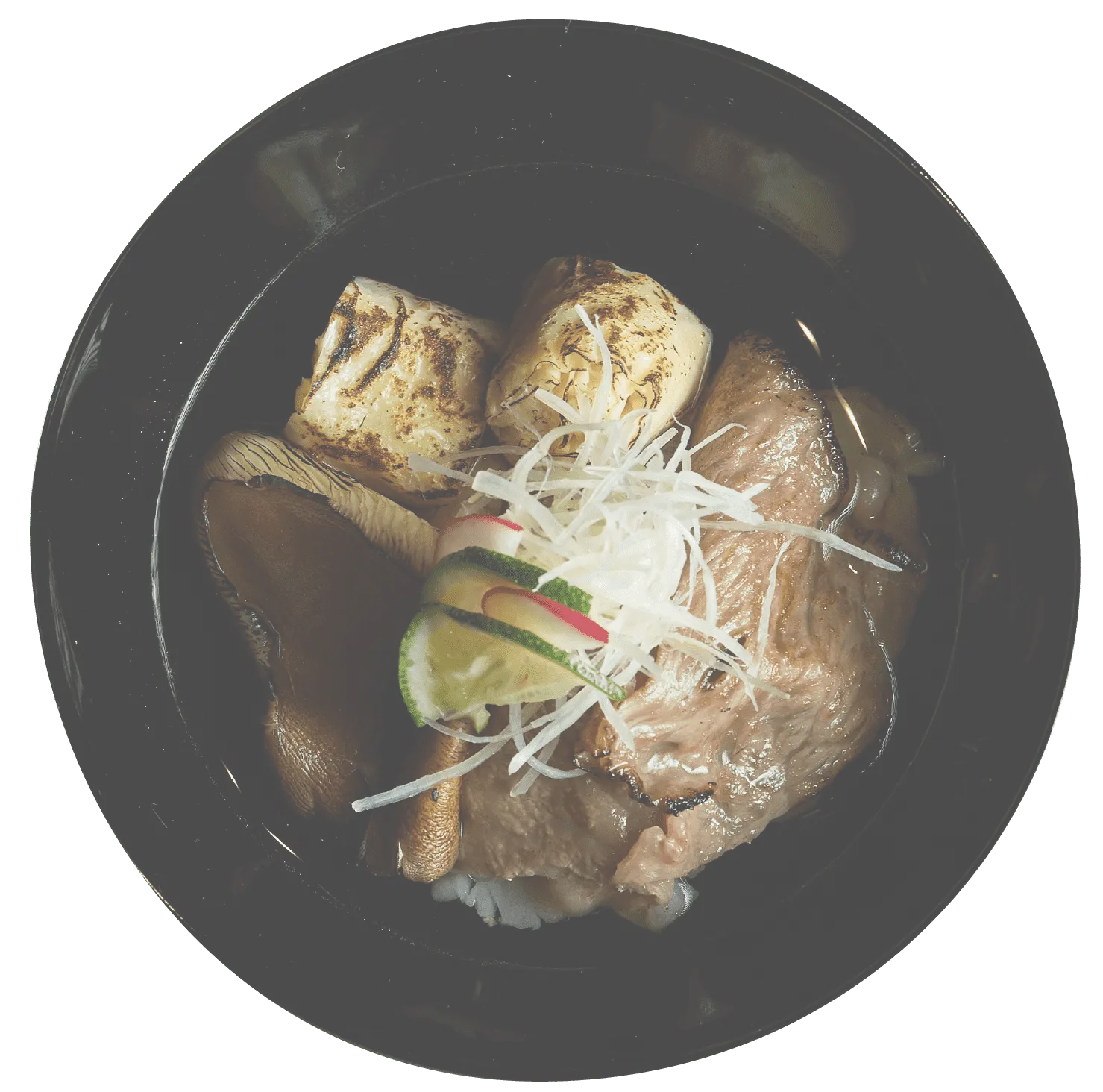 黒いお椀に盛り付けられた、炙り肉、焼き野菜、薬味が添えられた上品な一品。