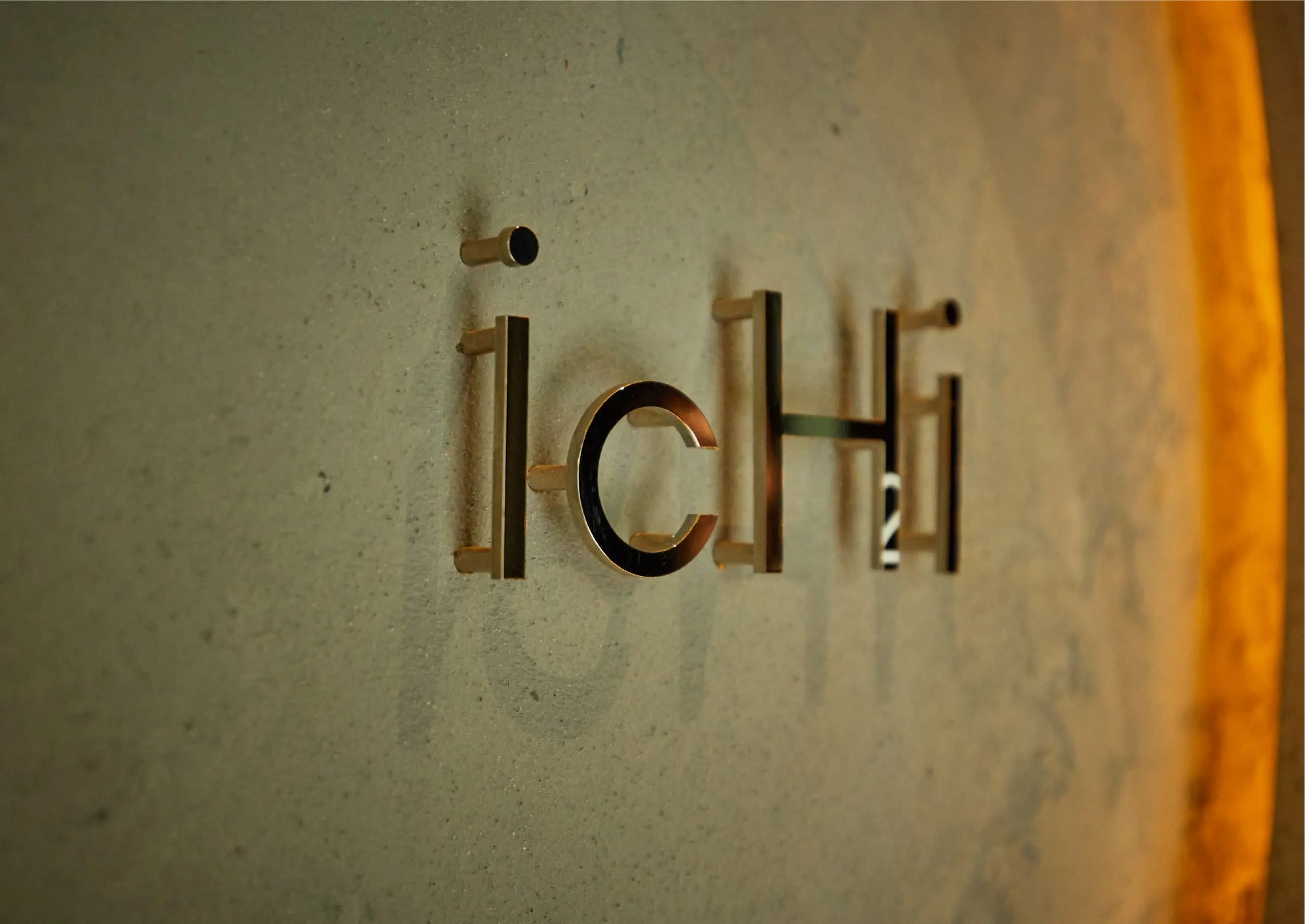 壁に取り付けられたレストラン「ICHI」のスタイリッシュな金属製ロゴサイン